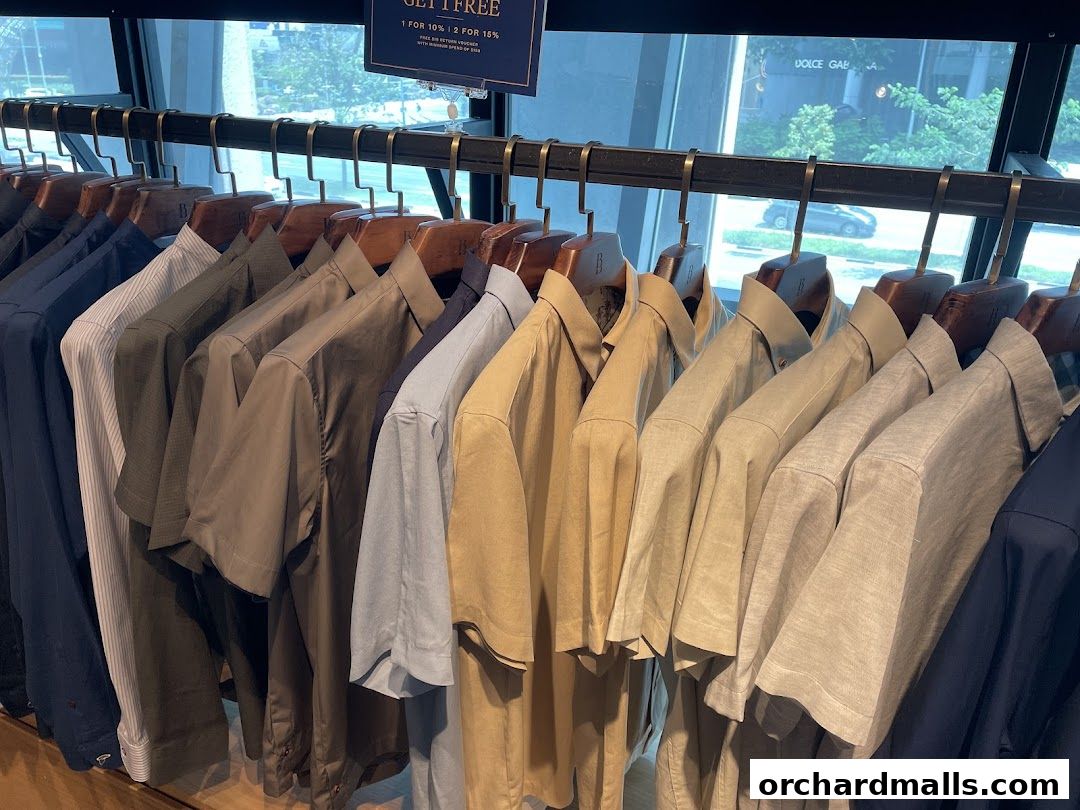 A rack of men's short-sleeved shirts in various neutral colors.