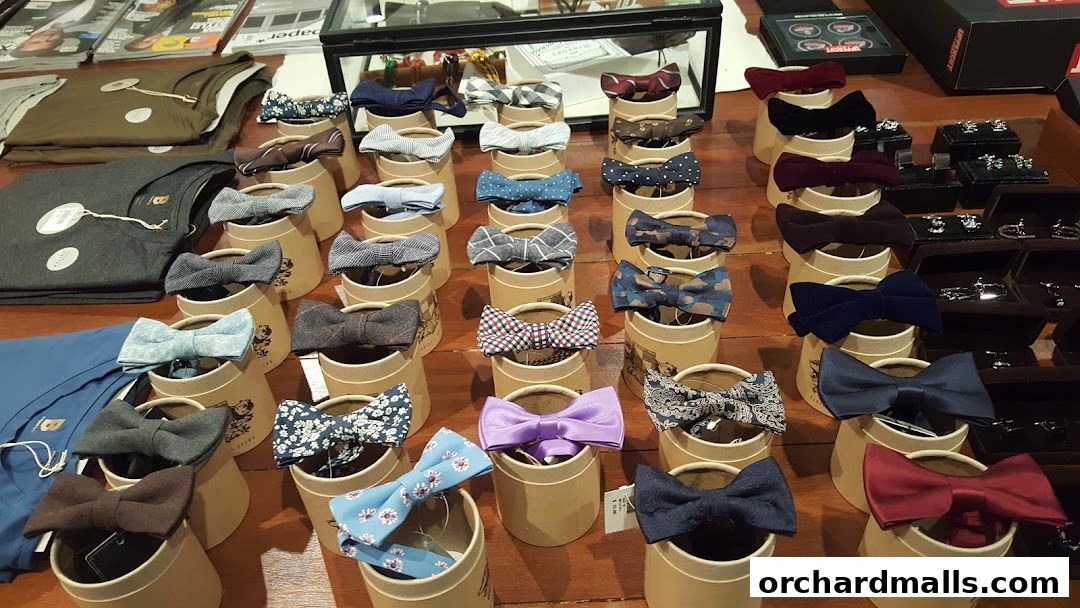 A display of various bow ties and shirts, showcasing different patterns and colors.