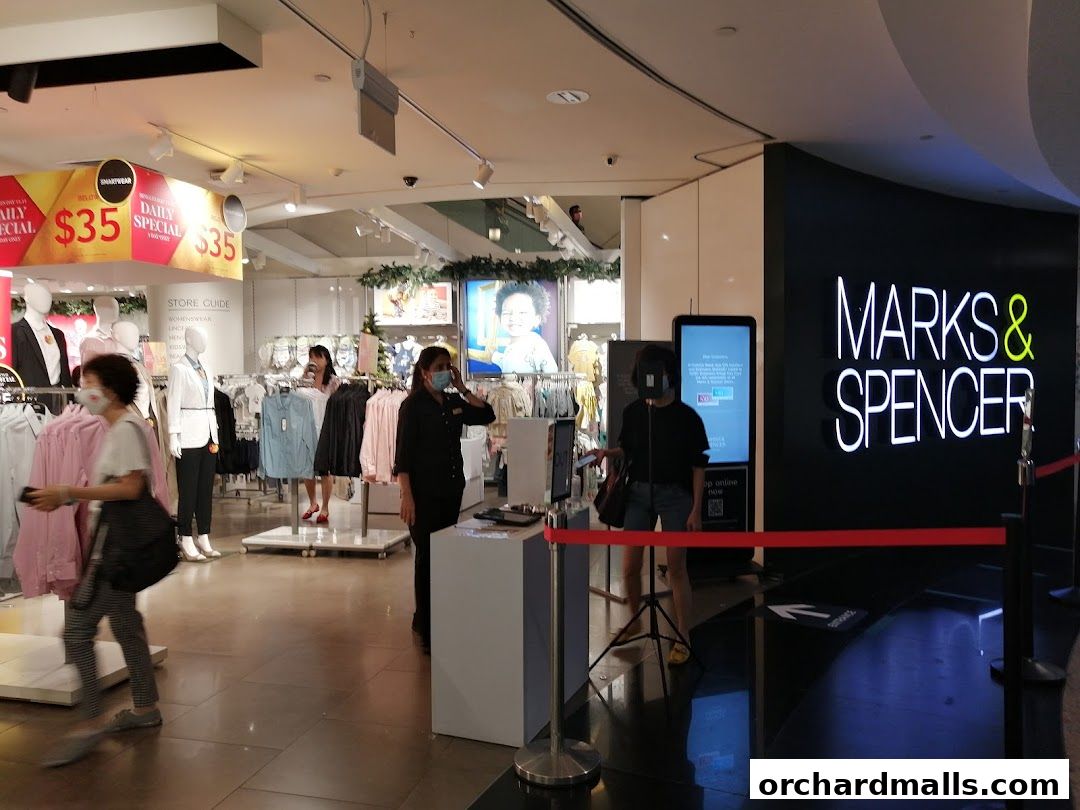 Interior of a Marks & Spencer store with clothing displays and signage.