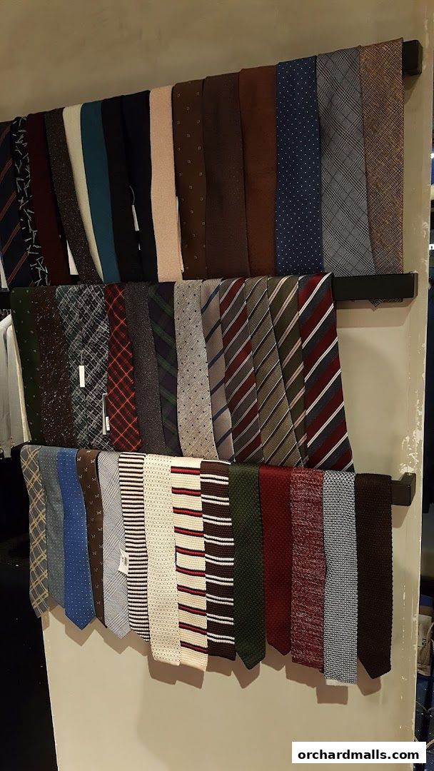A display of various ties in different patterns and colors hanging on racks.
