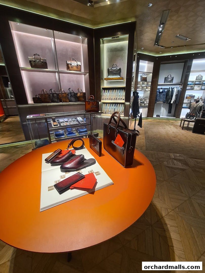 Luxurious BERLUTI store interior showcasing leather bags, shoes, and accessories on display.