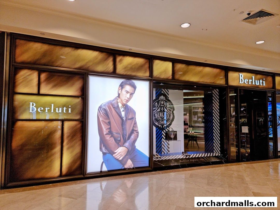 The exterior of a Berluti luxury fashion store with a large display featuring a model.