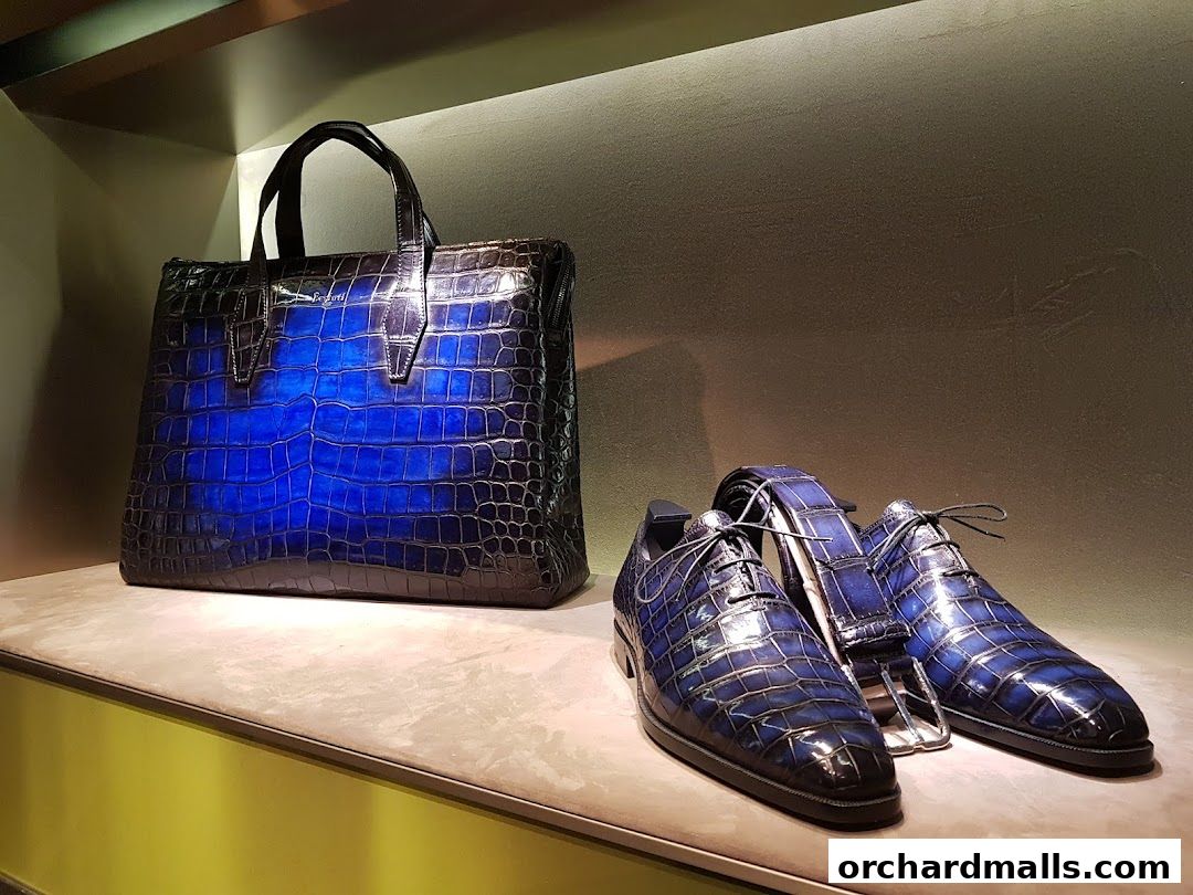 A luxurious blue alligator-patterned handbag and matching dress shoes displayed on a shelf.