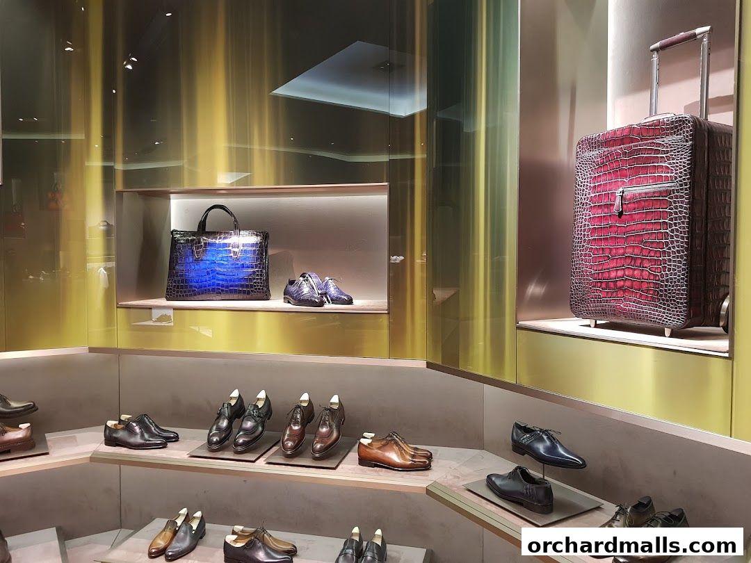 A luxury store window display featuring high-end leather shoes, handbags, and a suitcase.