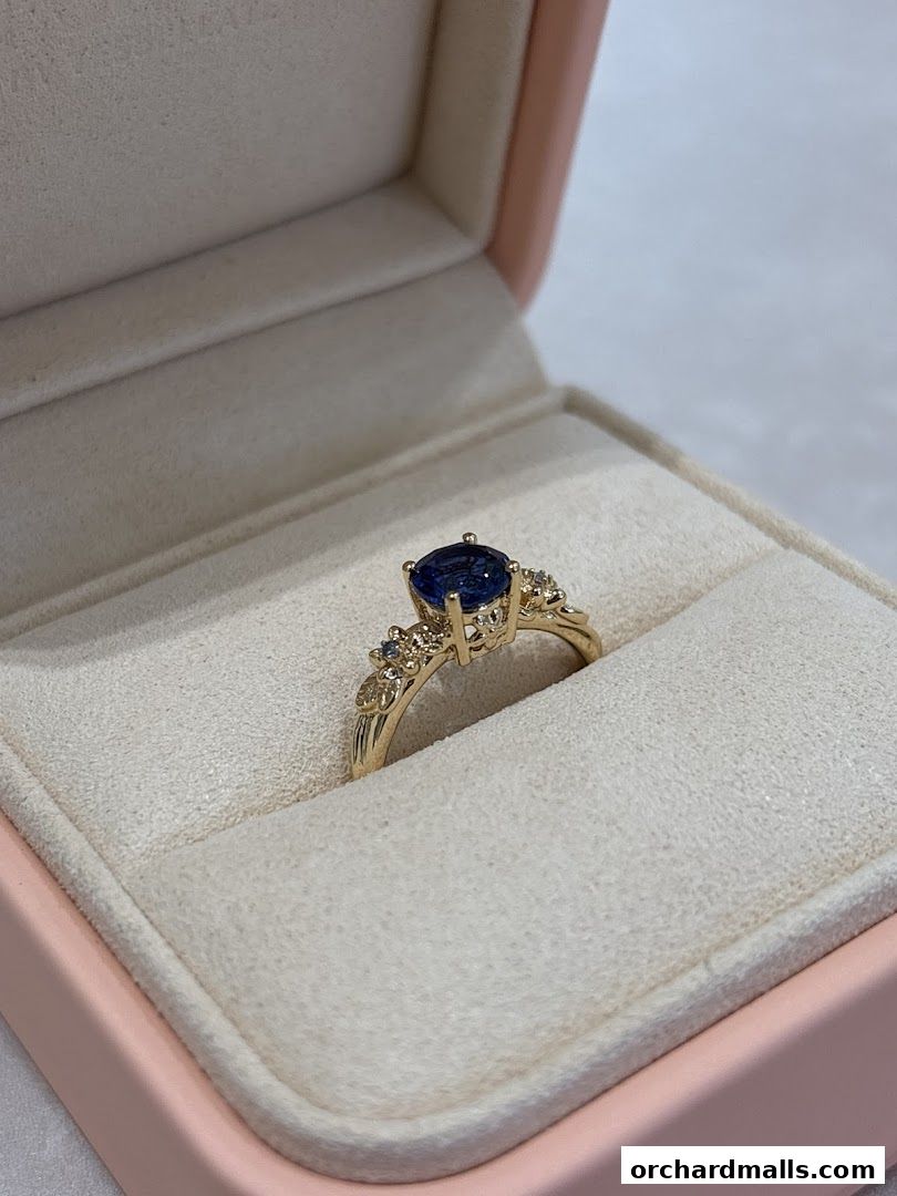 A stunning sapphire and diamond ring displayed in a pink jewelry box.