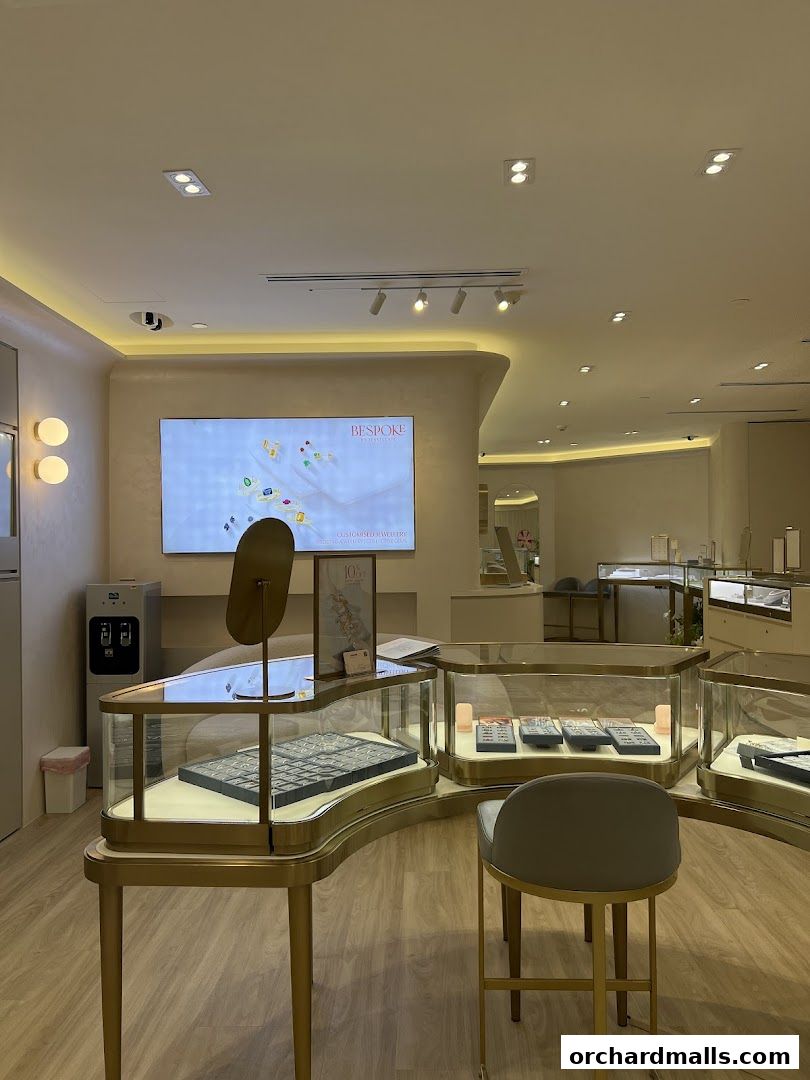 Interior view of a modern jewelry store with display cases and a large screen.