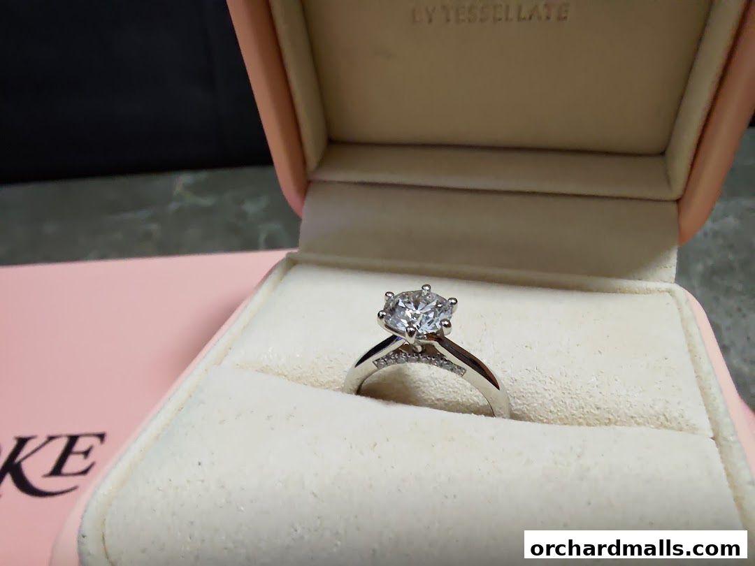 A diamond ring in a pink velvet jewelry box, with the brand name visible.