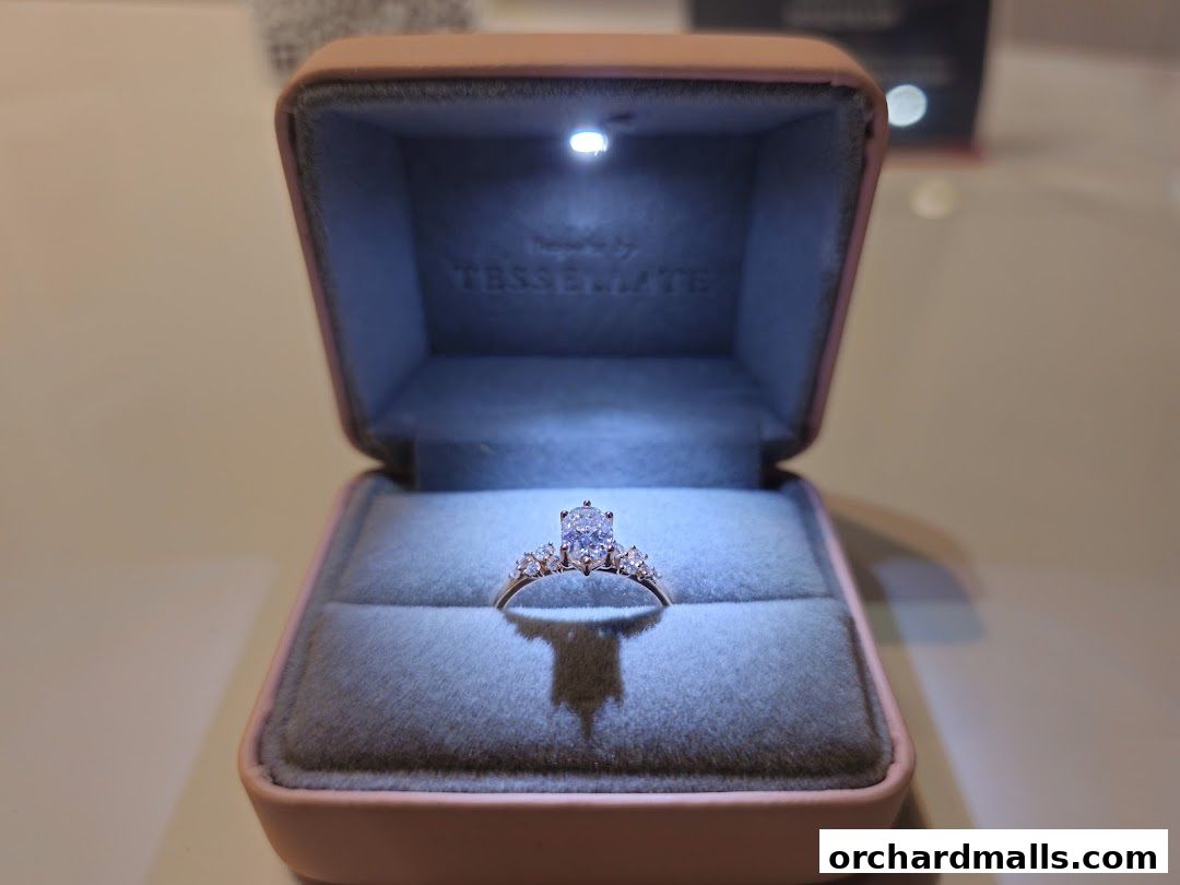 A diamond ring displayed in an open jewelry box with interior lighting.