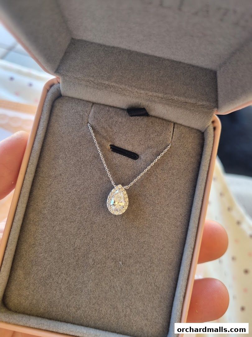 A pear-shaped diamond pendant necklace in a jewelry box.
