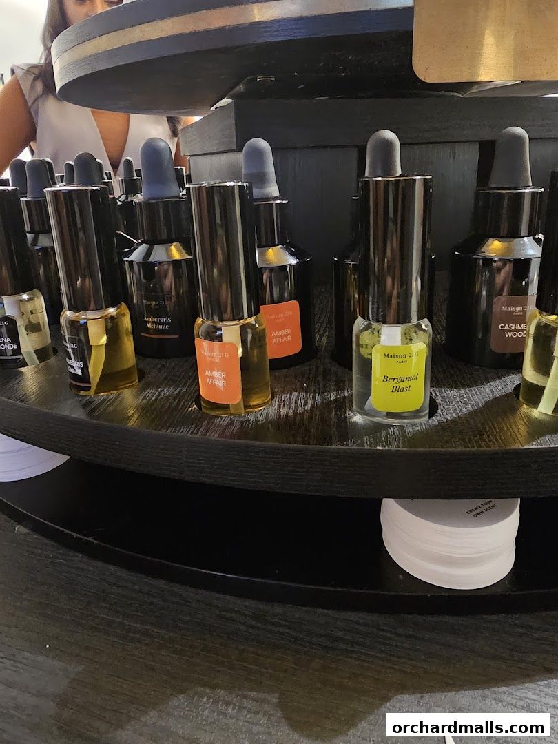 A display of small perfume bottles with dropper caps, featuring various scent names.