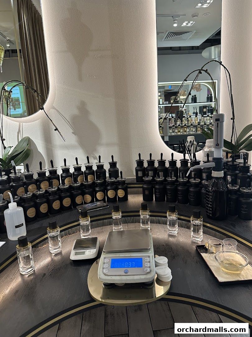 A display of perfume bottles and ingredients with scales for custom fragrance creation.