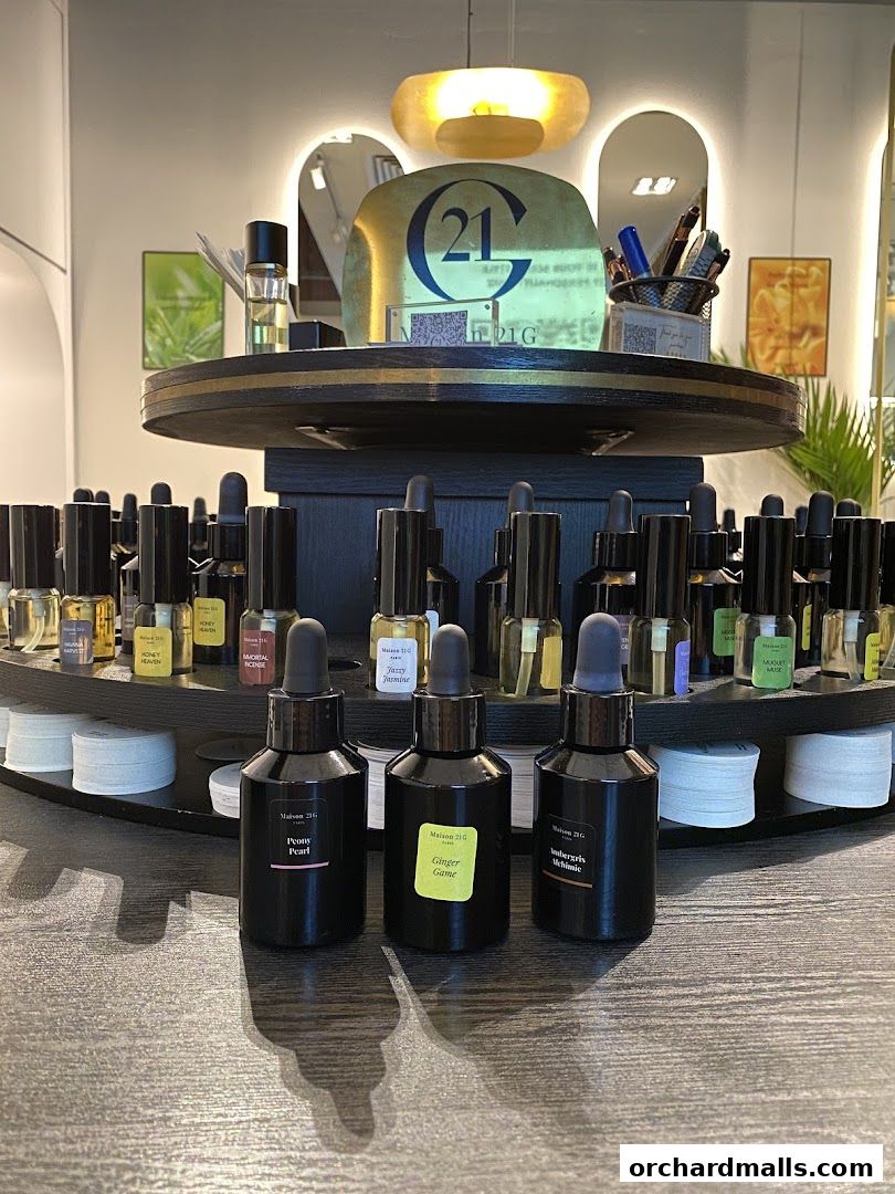 A display of various perfume bottles from Maison 21G, featuring different scents.