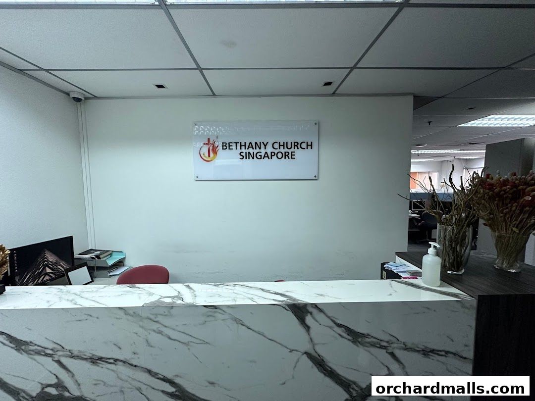 Reception area of Bethany Church Singapore with a marble counter and church logo.