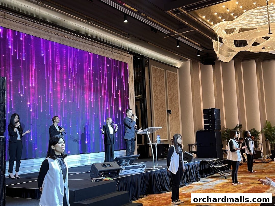 A choir performs on stage with a large LED screen displaying a vibrant light show.