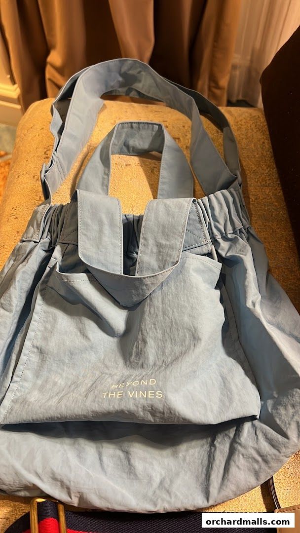 A light blue tote bag with the brand name 'Beyond The Vines' printed on it.