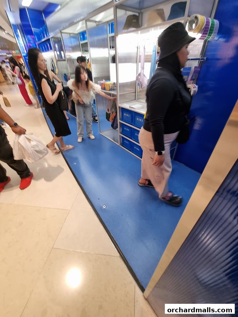 People browsing a modern retail display with blue accents and various products.