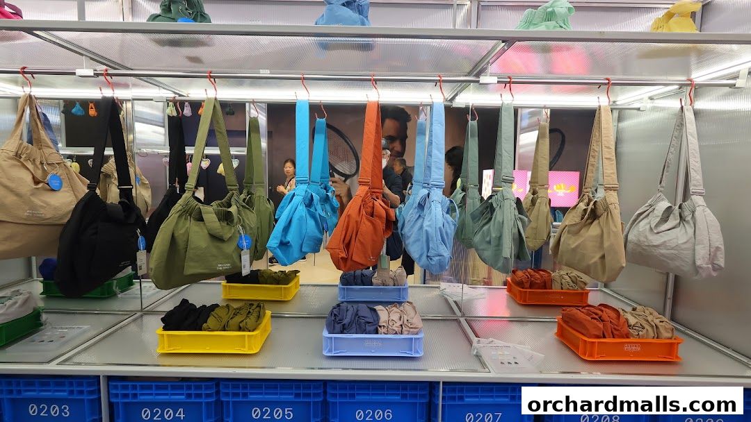 A display of various colorful bags and folded clothing items in a retail store.