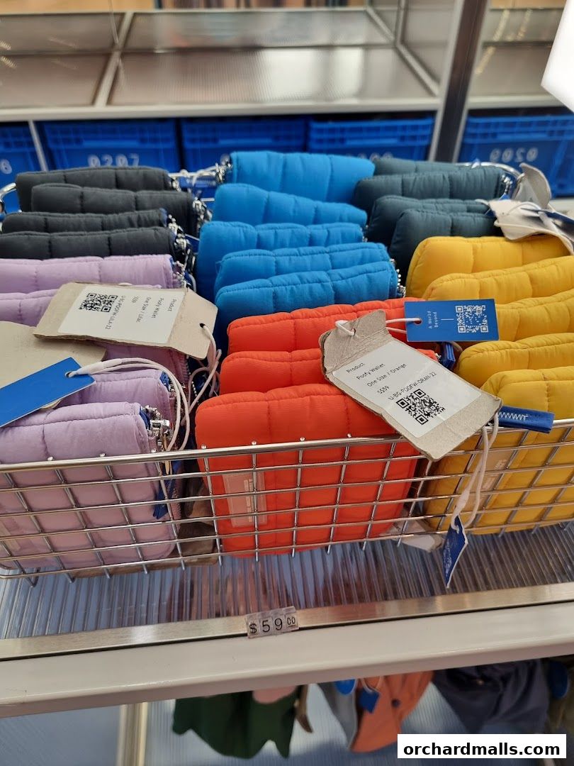 A display of colorful quilted wallets in various shades, neatly arranged in baskets.
