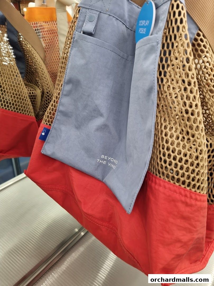 Close-up of a red and grey tote bag with a mesh exterior from Beyond The Vines.