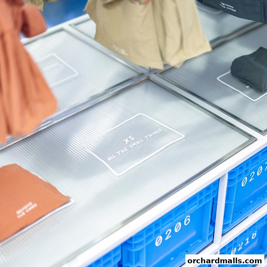 A display of clothing items and branded bags in a modern retail setting.