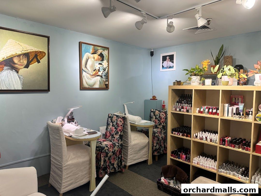 Interior of a nail salon with nail polish displays, manicure stations, and artwork.
