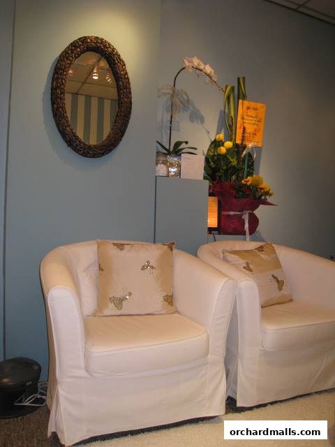 Two plush white armchairs with decorative pillows in a serene room.