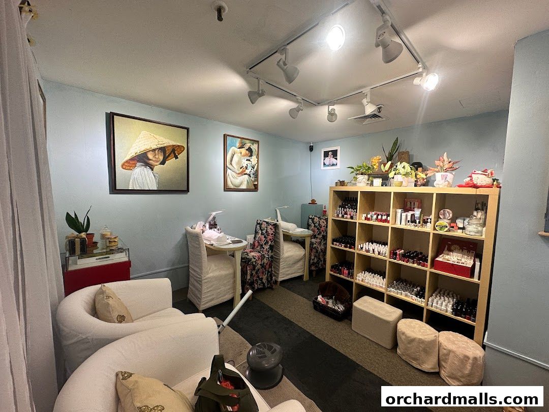 Interior of a nail salon with comfortable seating, nail polish display, and artwork.