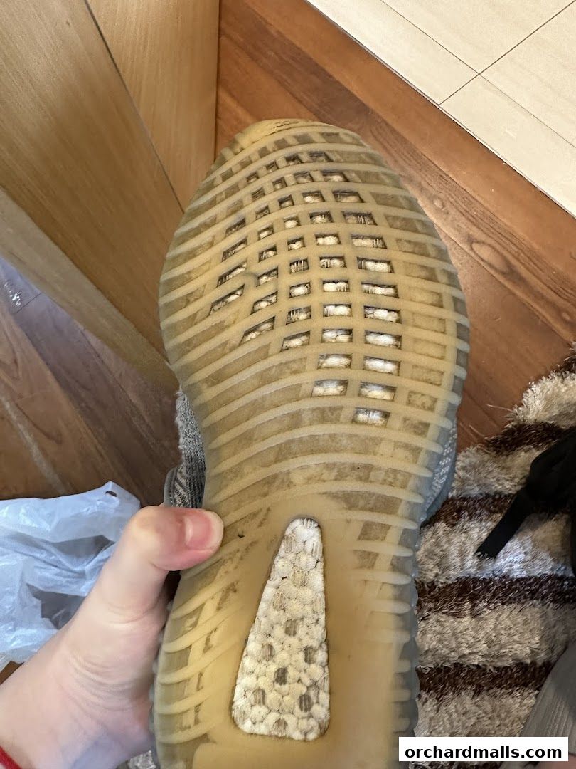 Close-up of the sole of a worn sneaker, showing the tread pattern and cushioning.