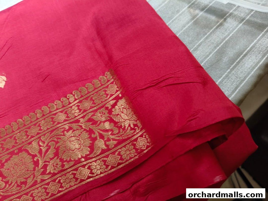 A close-up of a folded red fabric with a golden ornate border.
