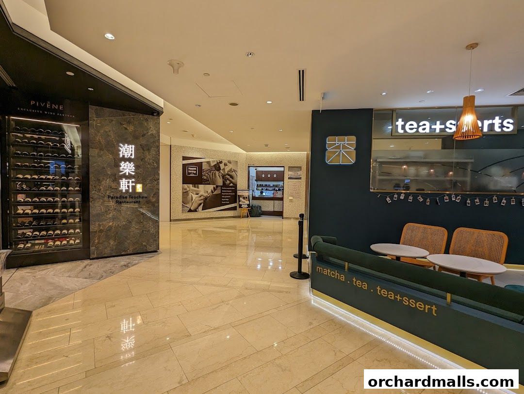 Interior view of a mall with a wine display, restaurant entrance, and a tea shop.