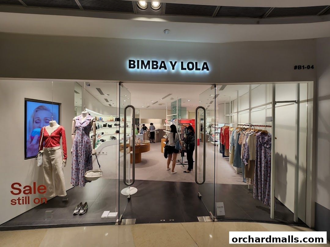 The BIMBA Y LOLA shop front displays mannequins with stylish outfits and racks of clothing inside.