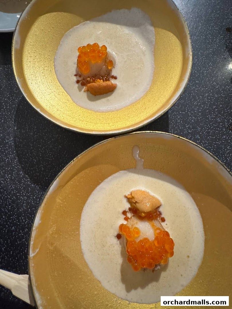 Two elegant bowls of creamy soup topped with uni, ikura, and a delicate piece of seafood.