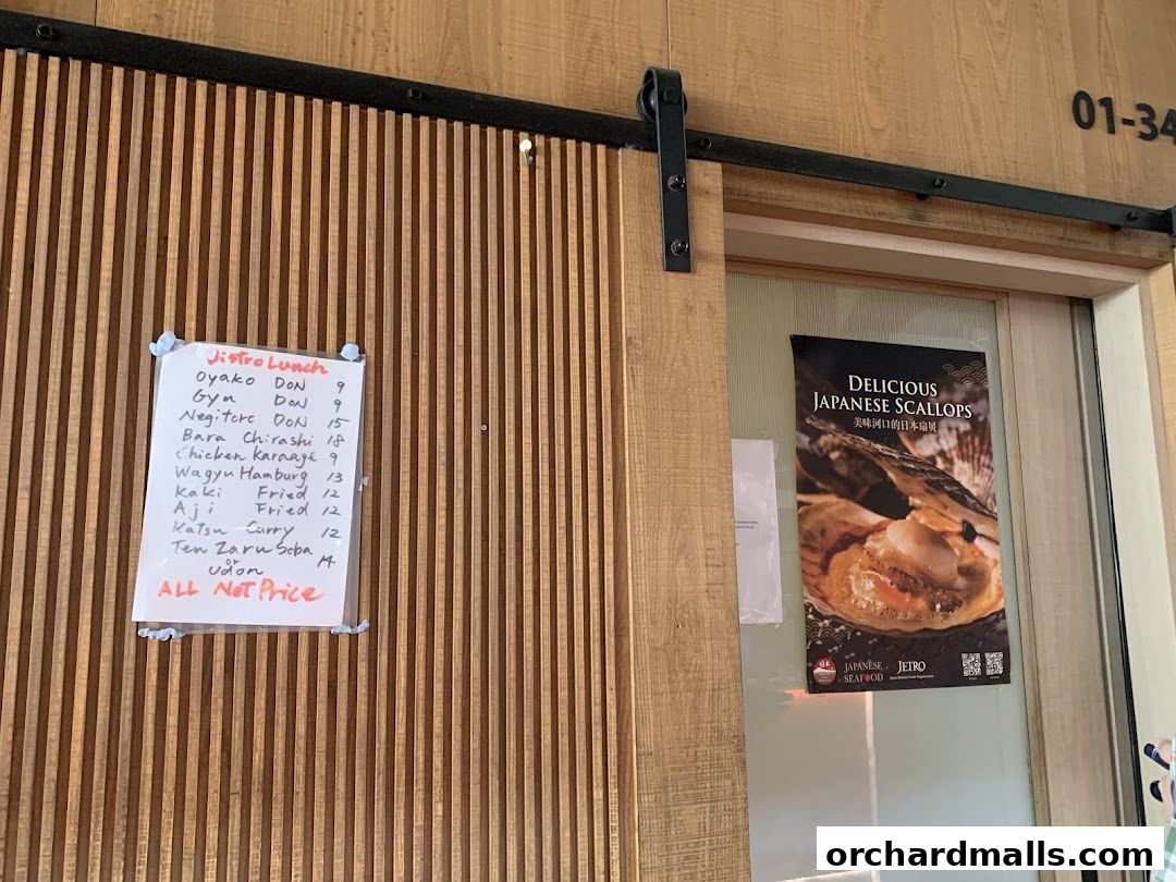 A handwritten lunch menu is displayed next to a poster advertising Japanese scallops.