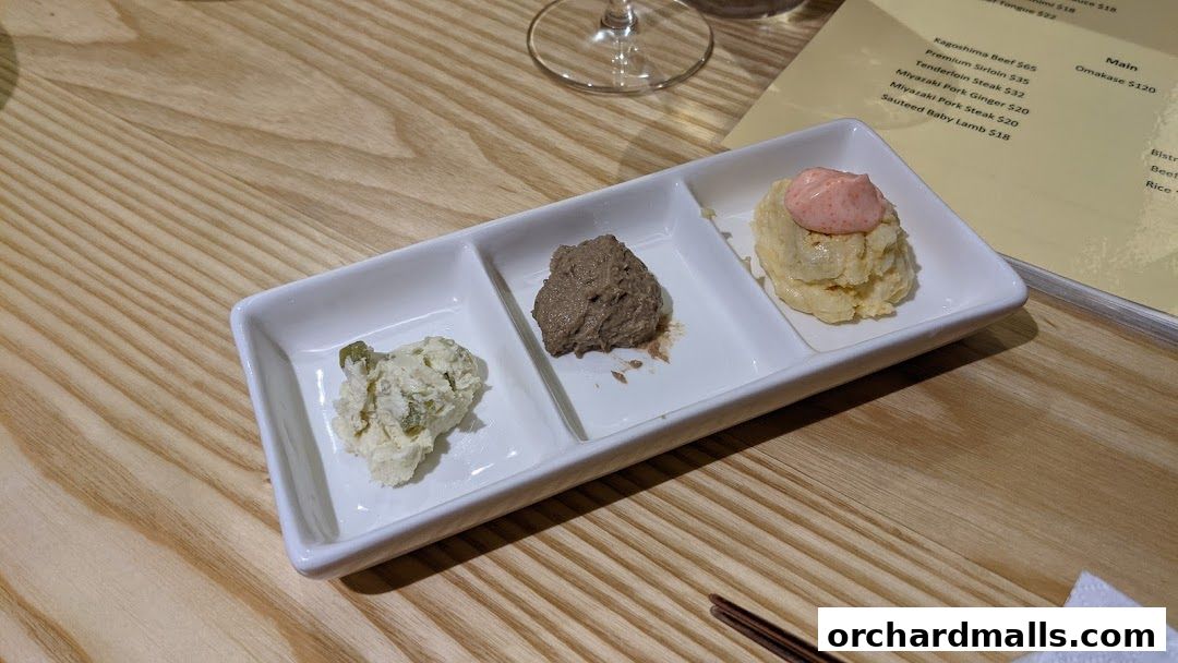 A tasting platter with three small portions of food next to a menu.