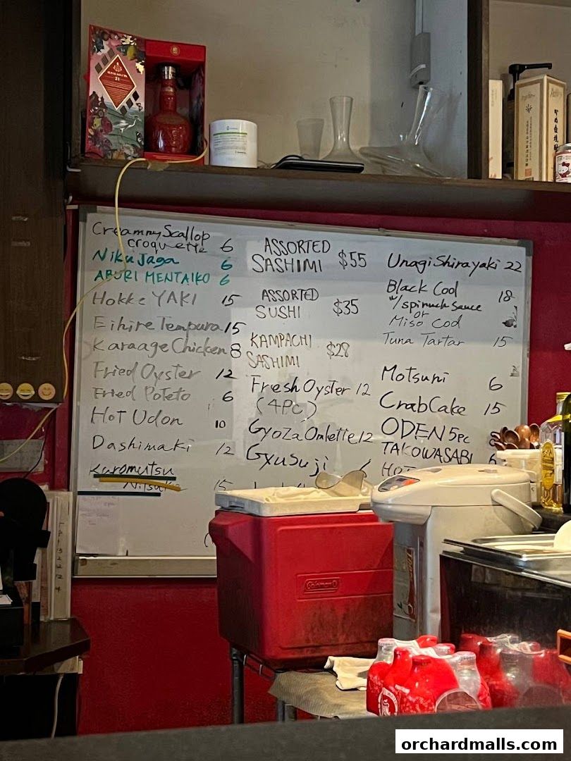 A whiteboard menu with Japanese food items and prices is displayed.