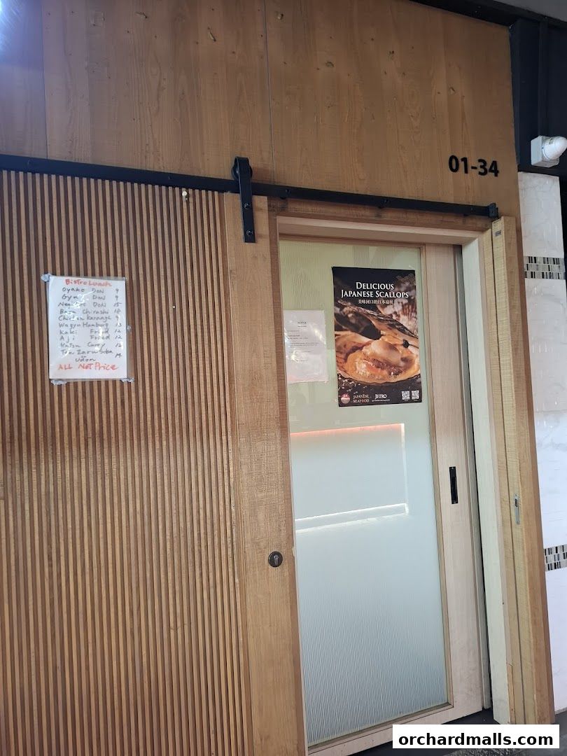 Exterior of Bistro Du Le Pin with a wooden door and a menu posted on the wall.