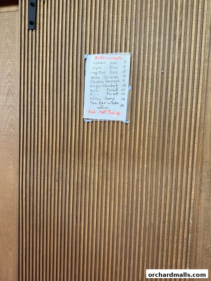 A handwritten lunch menu for Bistro Du Le Pin is displayed on a wooden wall.