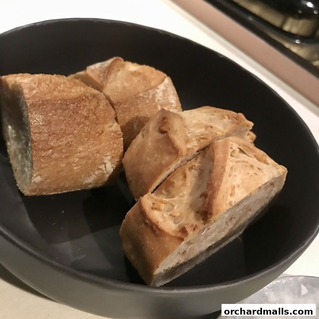 A dark bowl filled with freshly baked, sliced bread.