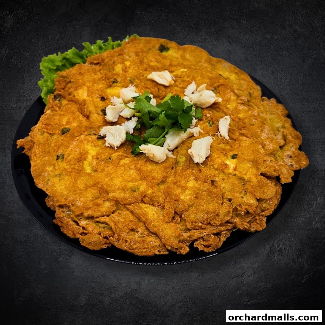 A large, golden-brown omelet topped with crab meat and cilantro on a black plate.
