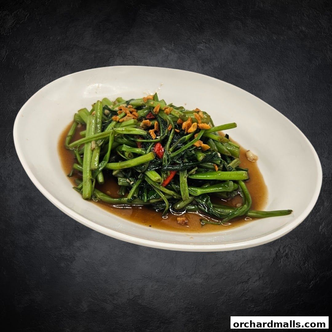 A plate of stir-fried morning glory with garlic and chili in a savory sauce.