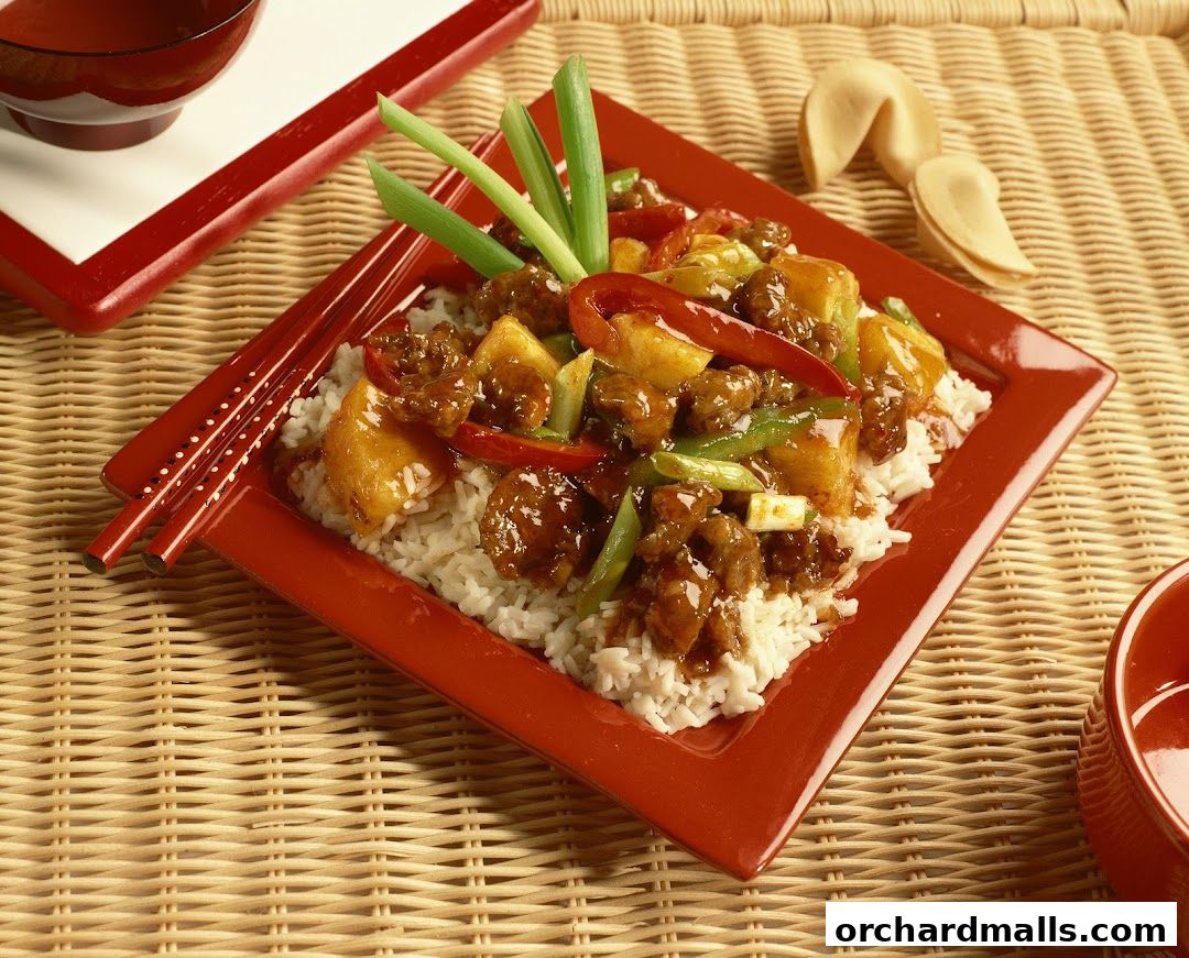 A delicious plate of Thai food with rice, meat, vegetables, and fortune cookies.