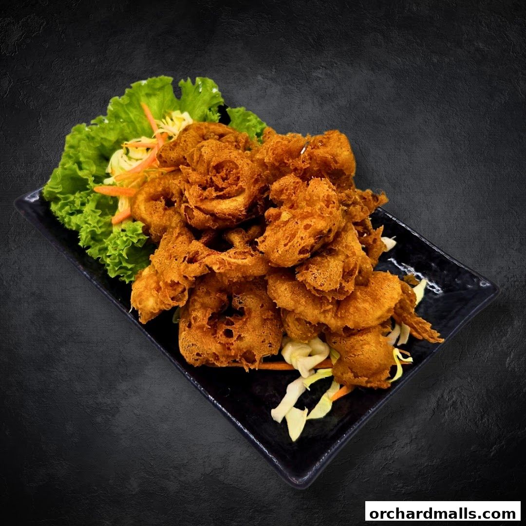 A plate of crispy fried calamari rings served with lettuce and shredded cabbage.