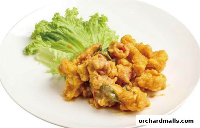 A plate of crispy fried calamari with lettuce garnish, coated in a savory sauce.
