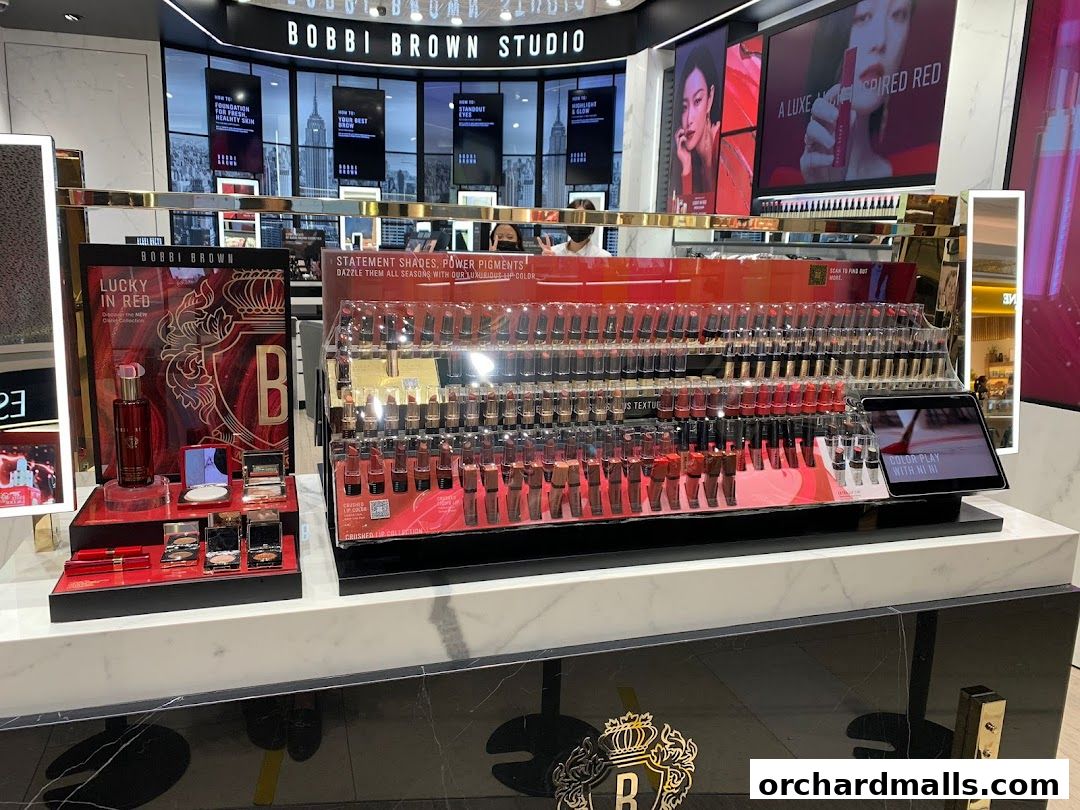 A display of Bobbi Brown lipsticks and makeup products in a well-lit studio setting.