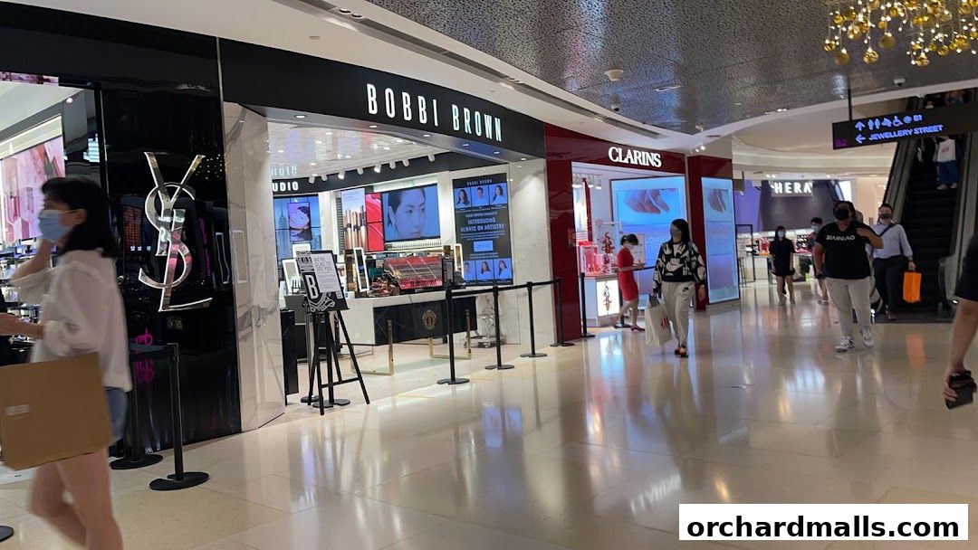 A view of the Bobbi Brown makeup store entrance and surrounding shops in a mall.