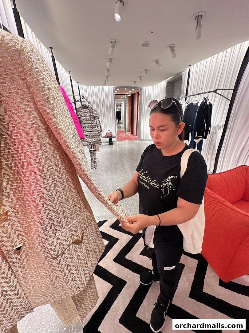 A woman examines a textured jacket in a modern boutique with stylish decor.