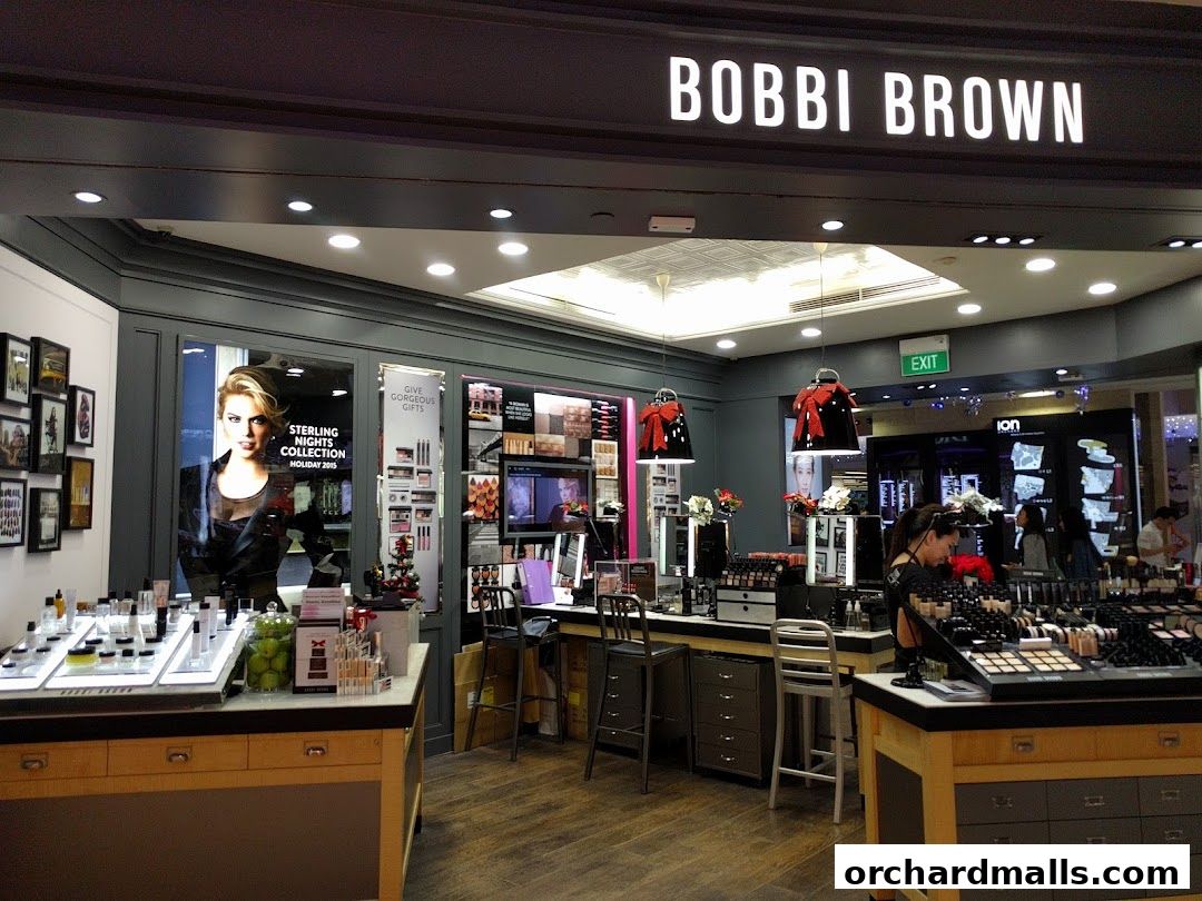 Interior view of a Bobbi Brown cosmetics store with makeup displays and staff.
