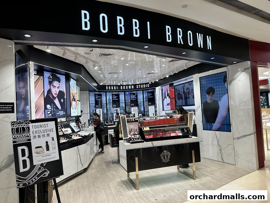 The exterior of a Bobbi Brown cosmetics store with displays of makeup and promotional screens.
