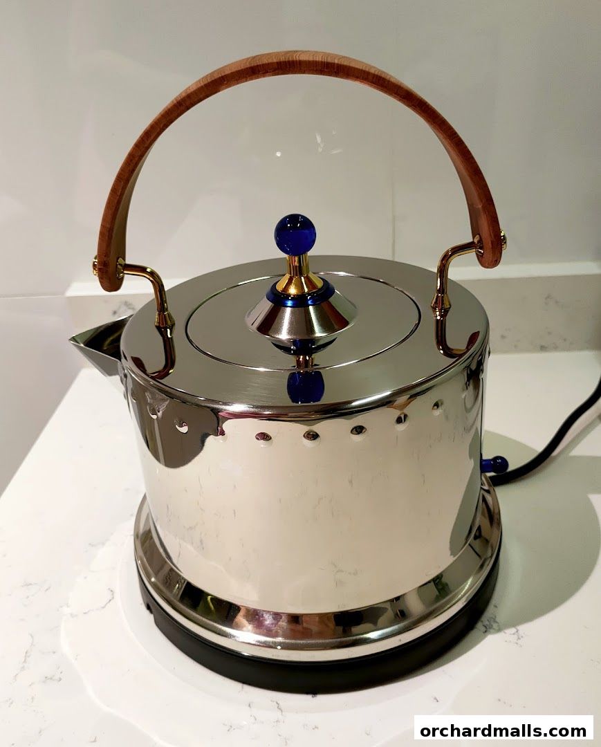 A polished stainless steel electric kettle with a wooden handle and blue accents.