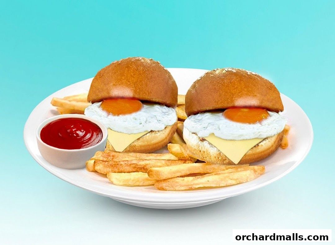 Two mini burgers with fried eggs, cheese, and fries on a plate with ketchup.